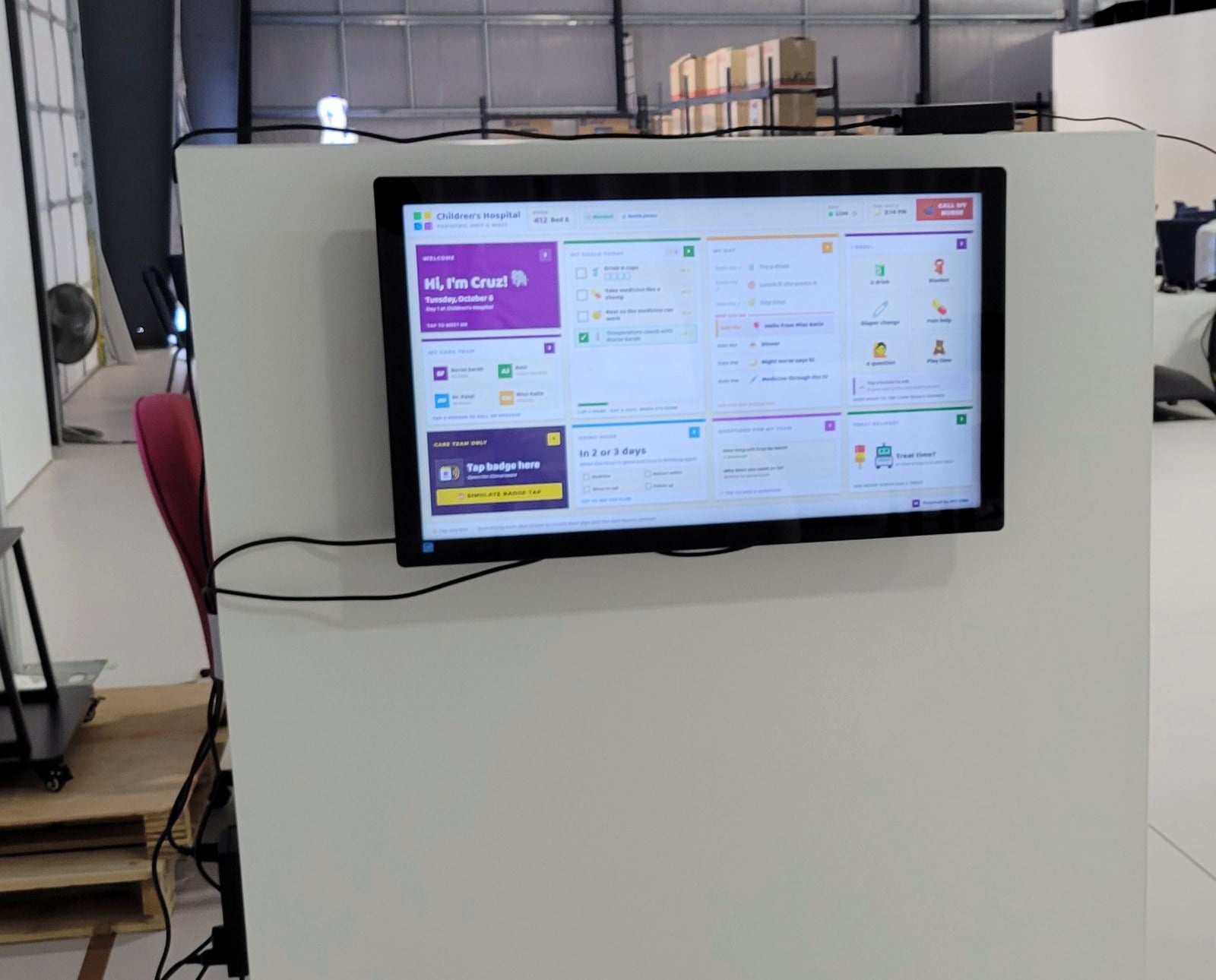 An HCI ONE patient whiteboard on a wall-mounted display